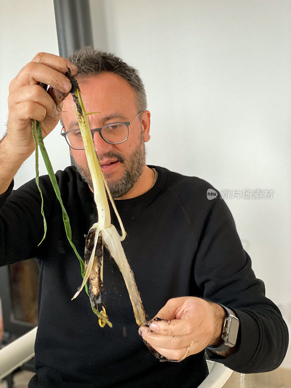 Man peeling a ‘calçot’, a kind of roasted spring onion or scallion